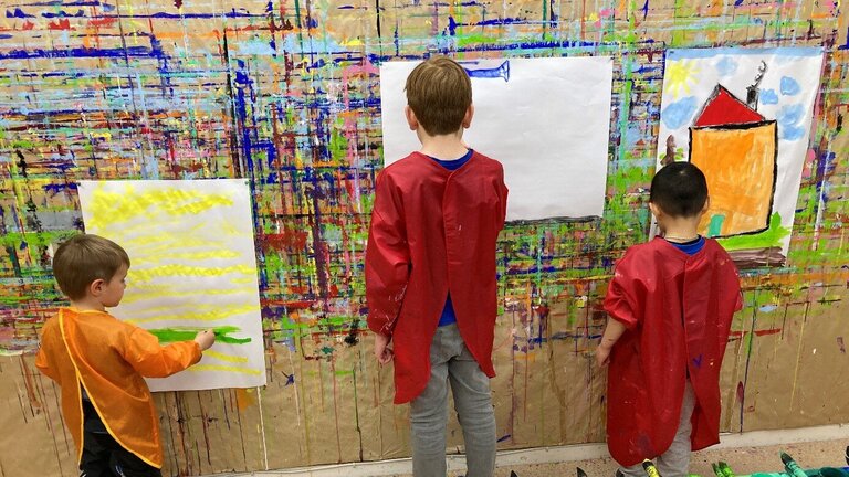 Kinder gestalten kreativ eine bunte Wand 
